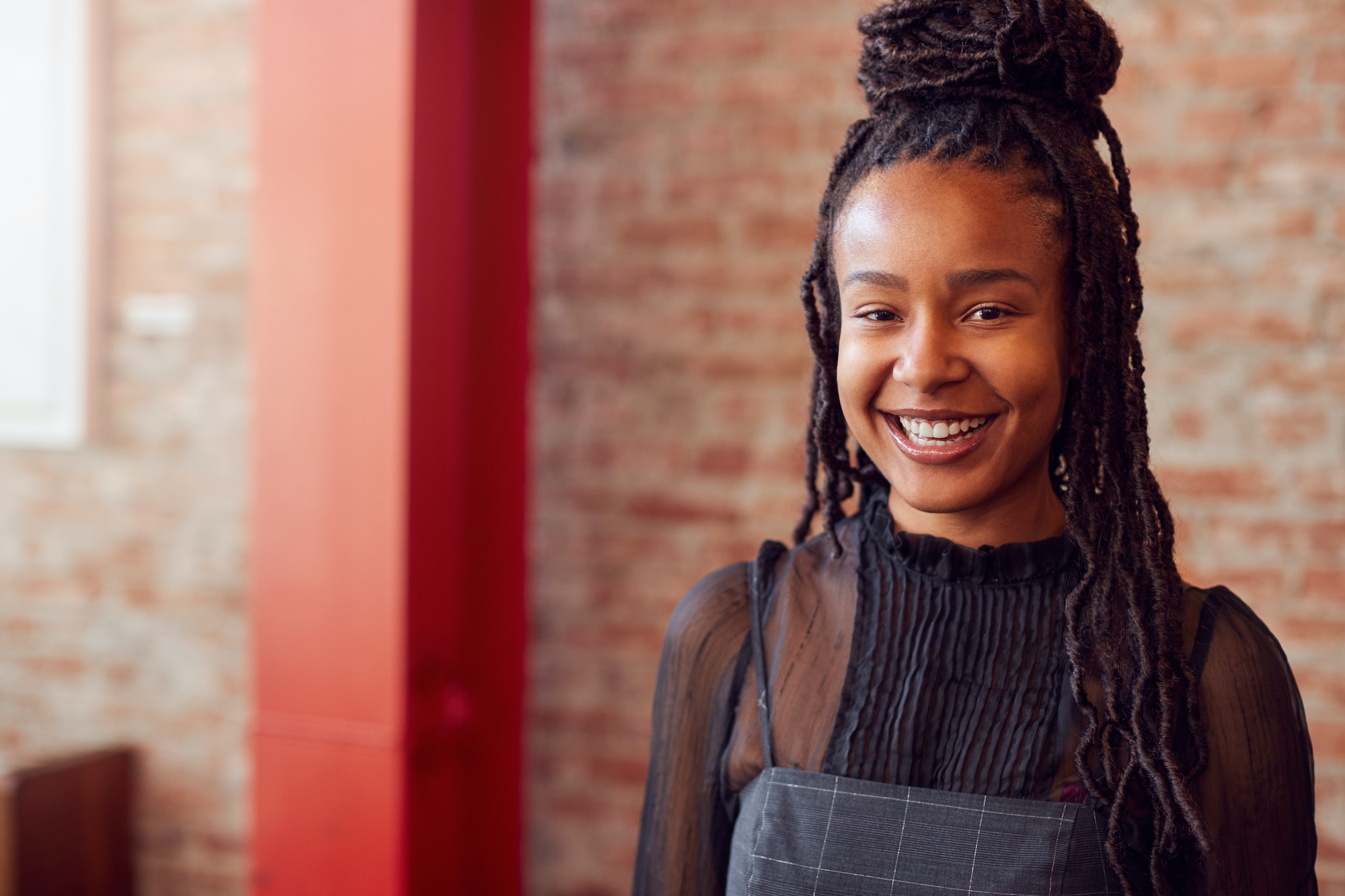 Portrait Of Smiling Female Coffee Shop Owner Wearing Apron